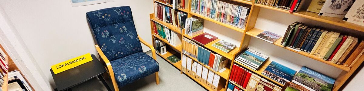 Bøker, bokhyller, stolar, kart, bord, skilting, bibliotek